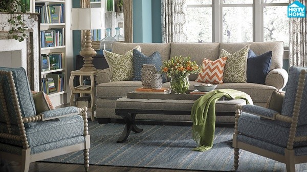 luxury living room featuring light blue color scheme with tan sofa with multi colored pillows, and two blue chairs