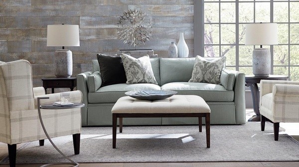 luxury living room featuring grey and tan furniture including a sofa, two chairs, small table, and two lamps