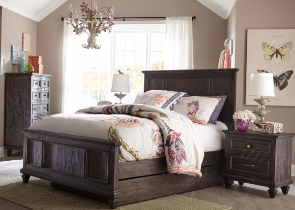 luxury finished interior bedroom with wooden bed frame, nightstand and armoire with multicolor floral bedding and accents