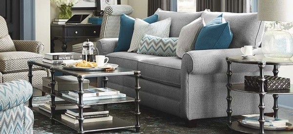 luxury living room featuring grey cloth sofa with multiple grey and teal pillows with metal tables, and multiple chairs